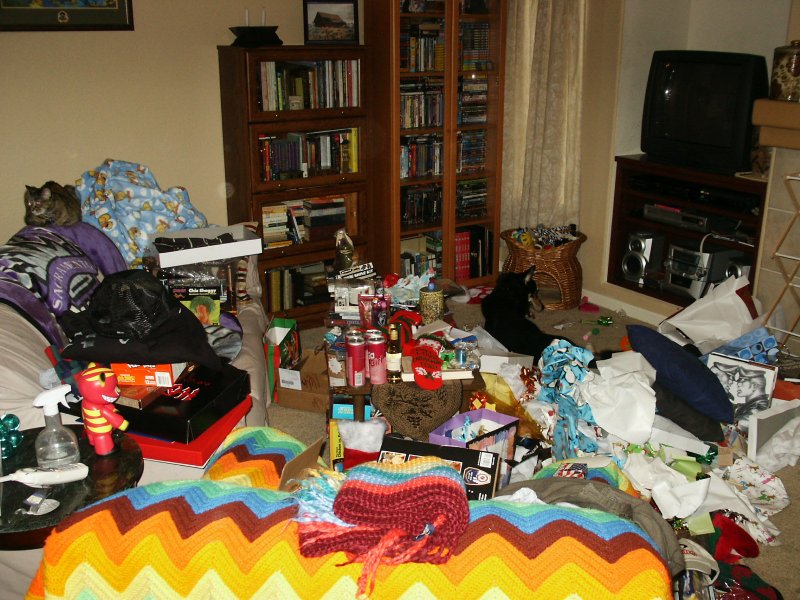 Before family room example with toys, bottles, blankets, and clutter covering the main seating area.